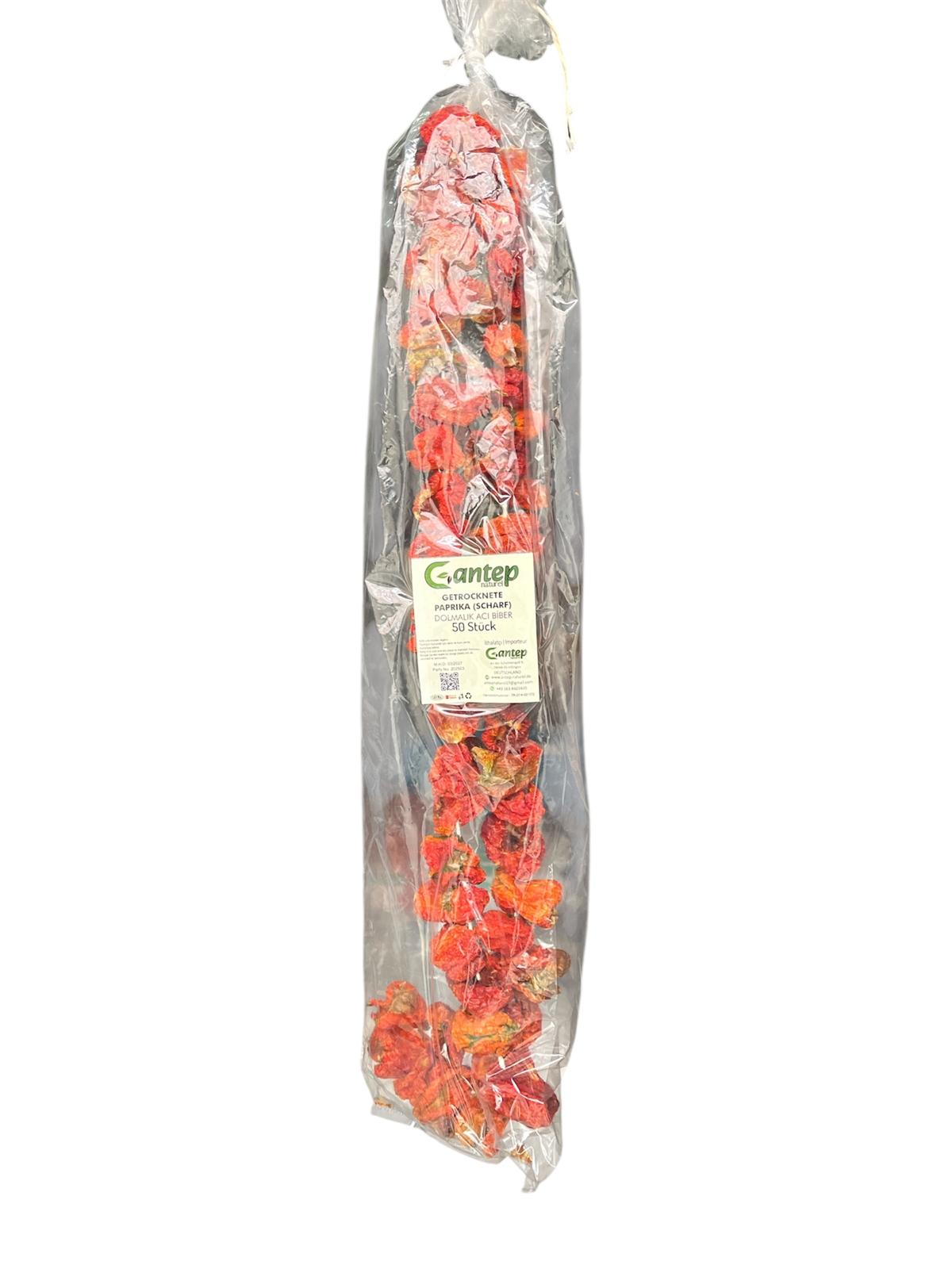 Transparent verpackte getrocknete, scharfe Paprika von Gantep Naturel, 50 Stück, in durchsichtiger Kunststoffverpackung mit grün-weißem Etikett, fotografiert auf hellem Hintergrund.