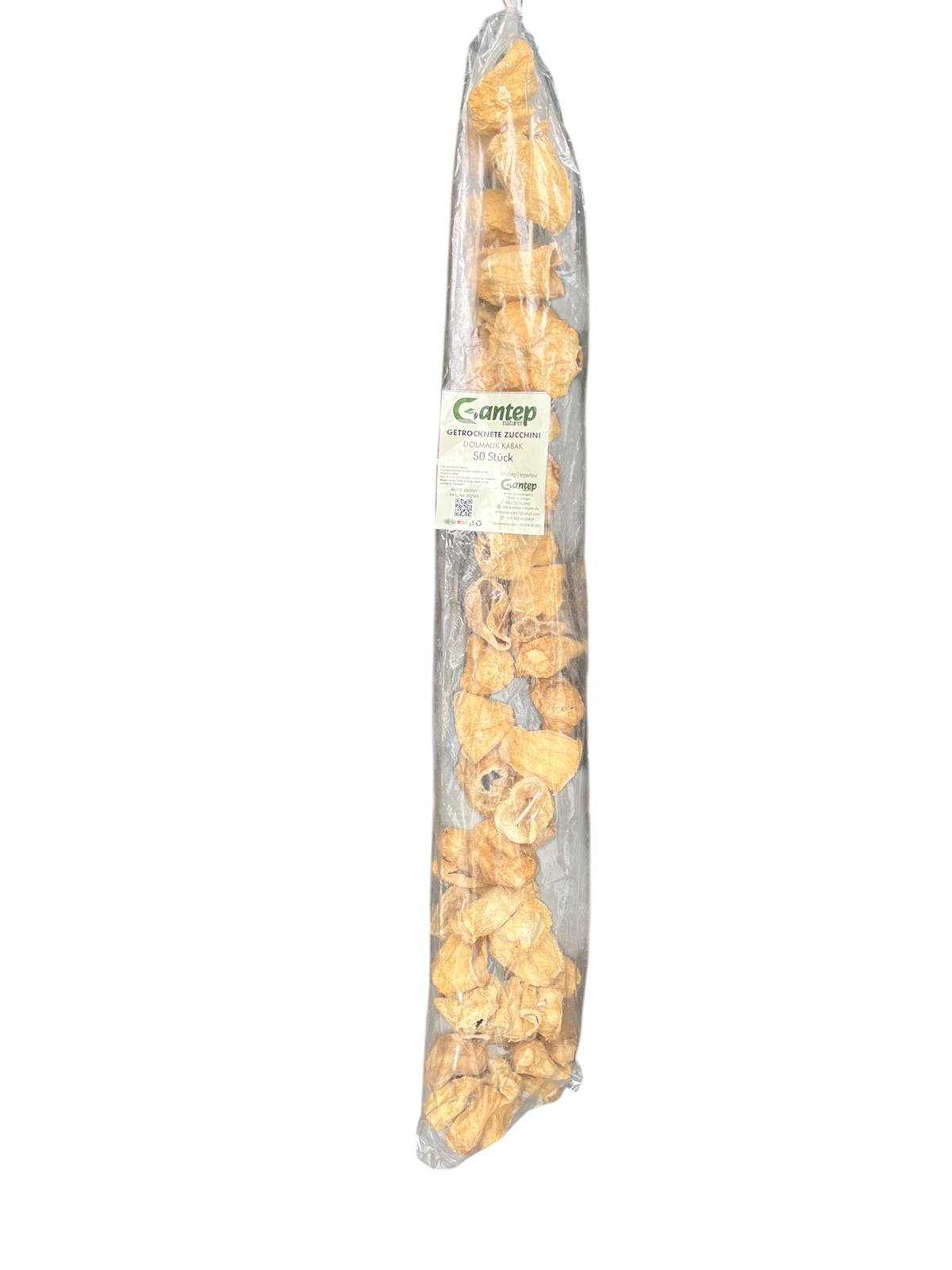 Verpackung mit 50 getrockneten Zucchiniringen von Gantep Naturel, aufgehängt in transparenter Folie mit grünem Etikett „Dolmalık Kabak“, fotografiert auf hellem Hintergrund.