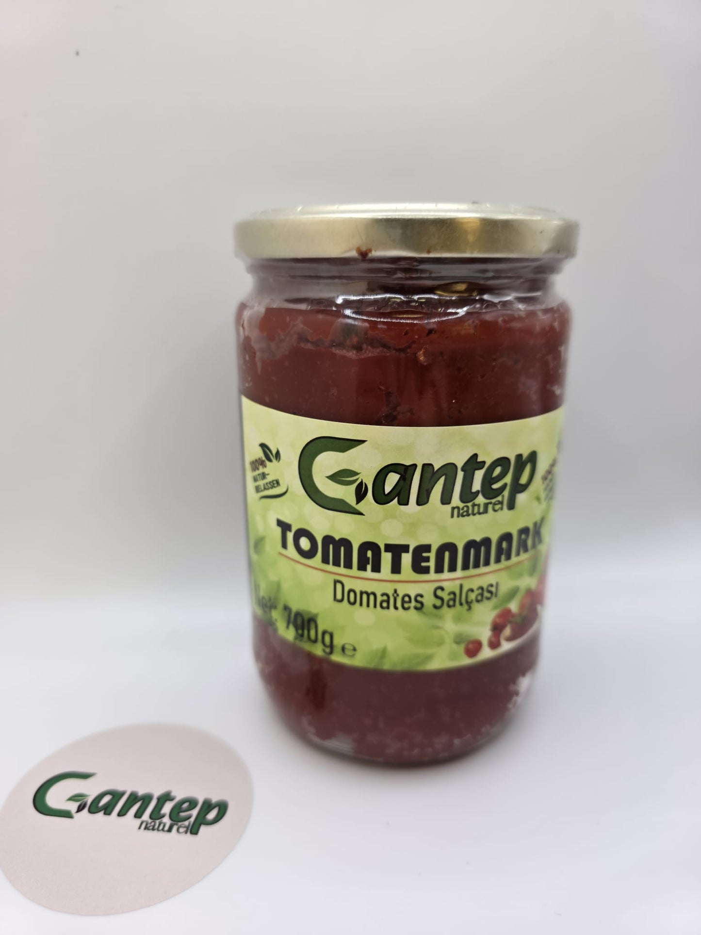 Dritte Frontalansicht des Gantep Naturel Tomatenmark-Glases, leicht nach rechts geneigt, auf hellem Untergrund.