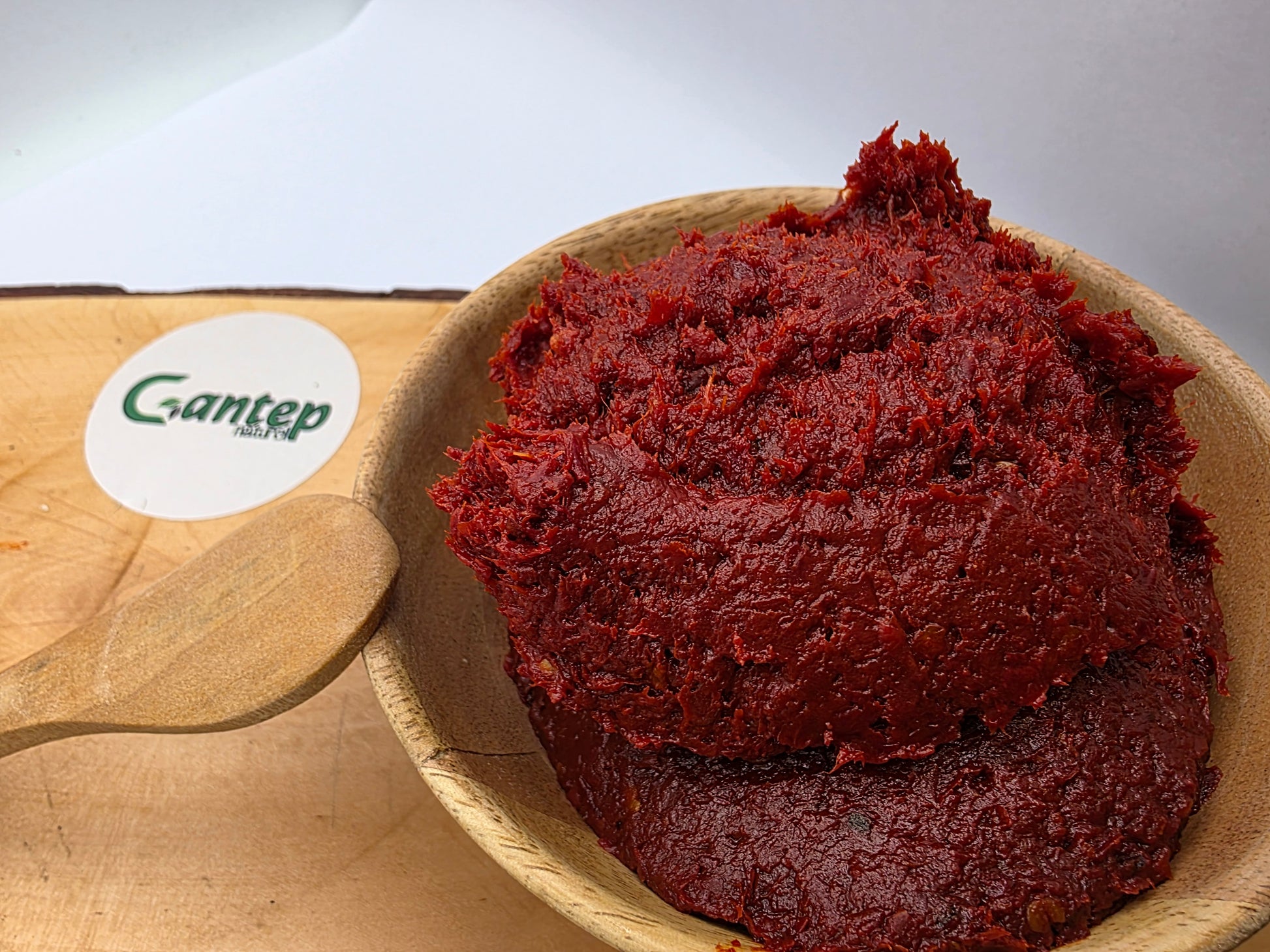 Fruchtiges, mildes Paprikamark von Gantep Naturel, angerichtet in einer Holzschale auf einem Holzbrett.